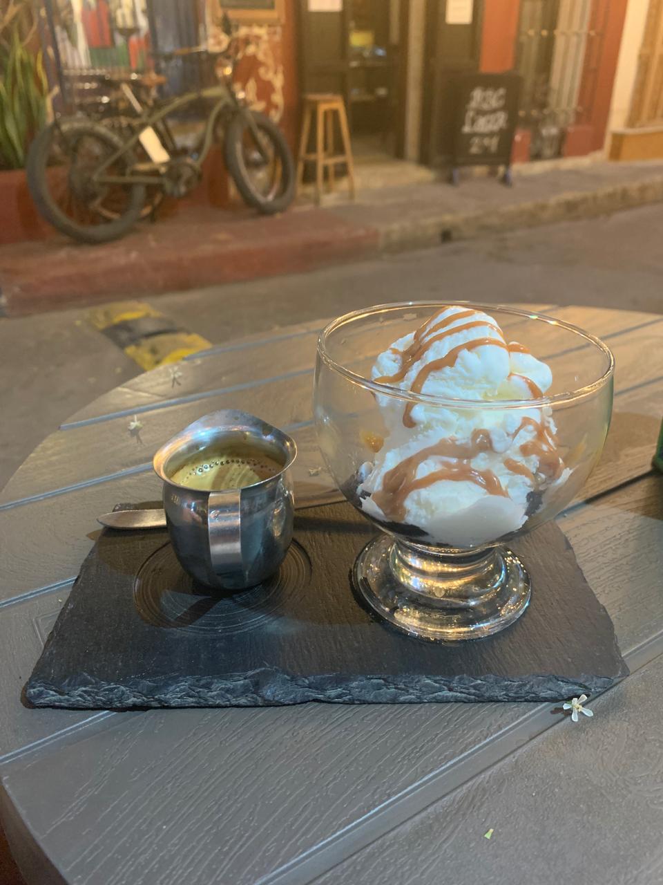 Affogato de Café del Mural: espresso en jarrita metálica junto a una copa de helado con caramelo, servidos sobre una pizarra de slate.
